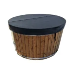 Ronde houten hottub met gesloten zwarte geïsoleerde afdekking in lederlook, middenvouw, handgrepen en bevestigingsriemen op witte achtergrond.