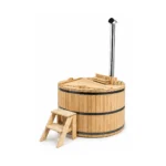Ronde massief houten hottub met licht houten buitenwand, drie donkere spanbanden, gesloten tweedelige houten afdekking, afgeschermde interne houtkachel, hoge roestvrijstalen schoorsteen en houten opstap met twee treden op witte achtergrond.