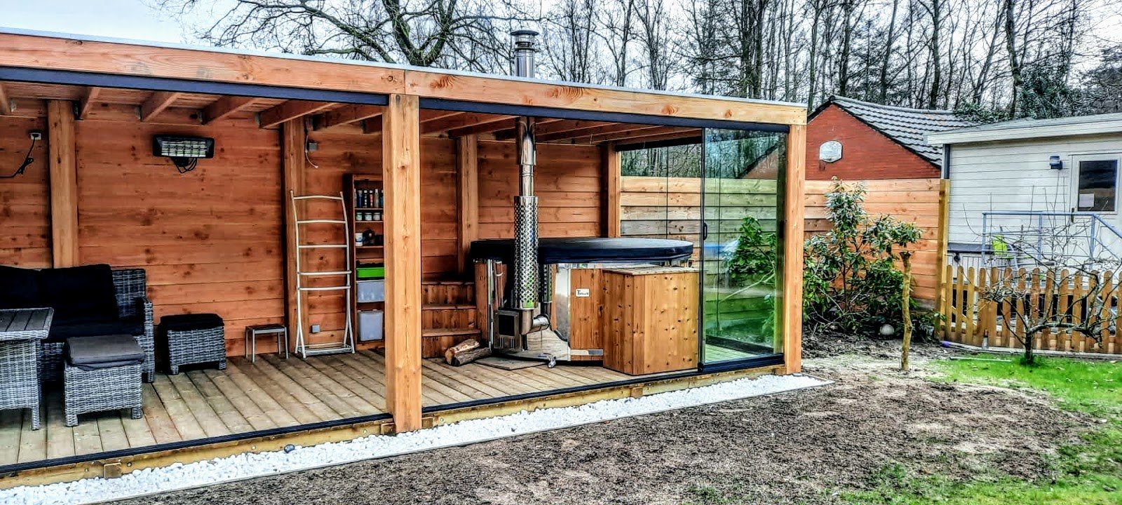 Houtgestookte hottub onder een tuinpaviljoen
