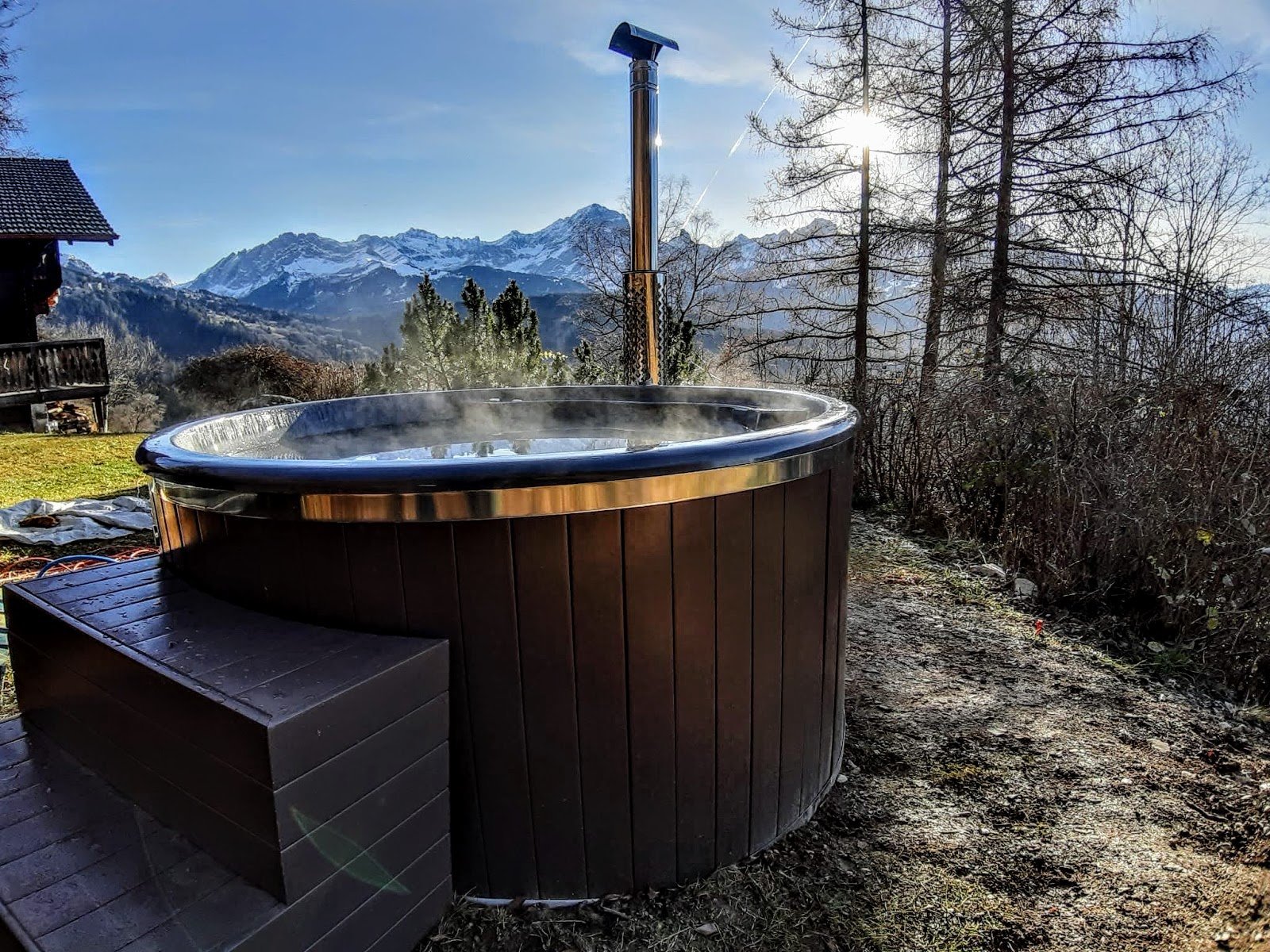 Dampende ronde houtgestookte hottub met externe kachel en rvs-schoorsteen voor besneeuwde bergen