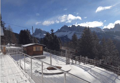 Afgedekte TimberIN hottub in een besneeuwde tuin