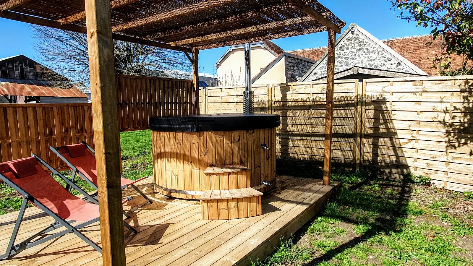Houten hottub met deksel en trap op een terras onder een pergola
