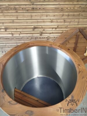 Bovenaanzicht in het lege TimberIN Icetub-koudwaterbad, met cilindrische rvs binnenkuip, donkere bodem, kleine houten trede en thermohouten frame