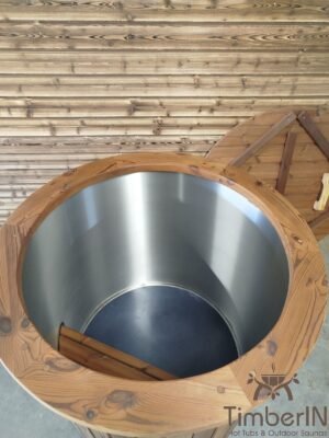 Bovenaanzicht in het open TimberIN Icetub-koudwaterbad, met geborstelde rvs binnenkuip, kleine houten zitstap, brede thermohouten rand en afdekking op de achtergrond