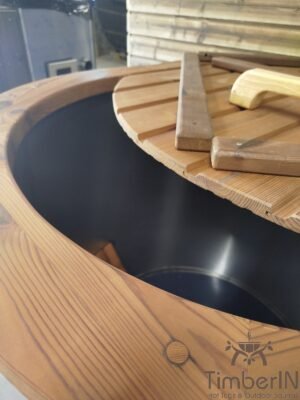 Close-up van het TimberIN Icetub-koudwaterbad van thermohout, met donkere binnenkuip, deels geplaatste houten afdekking en brede afgeronde badrand