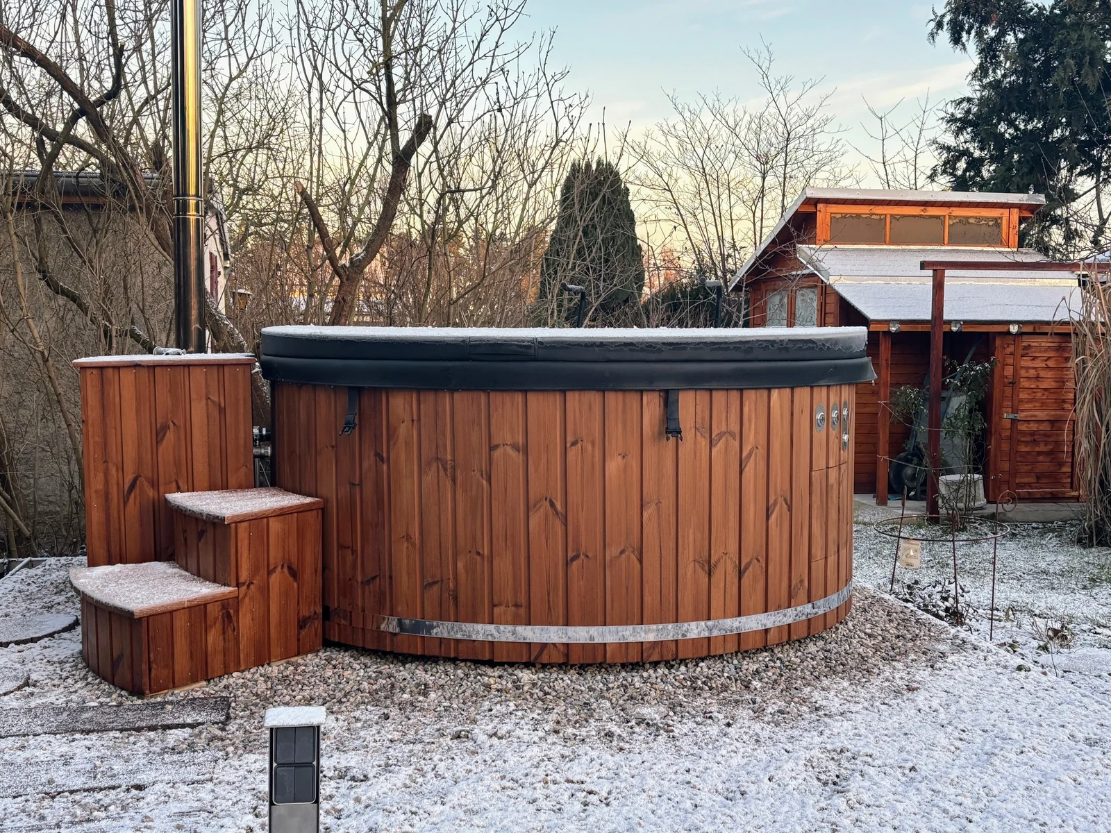 Hottub met afdekking en trap in een tuin