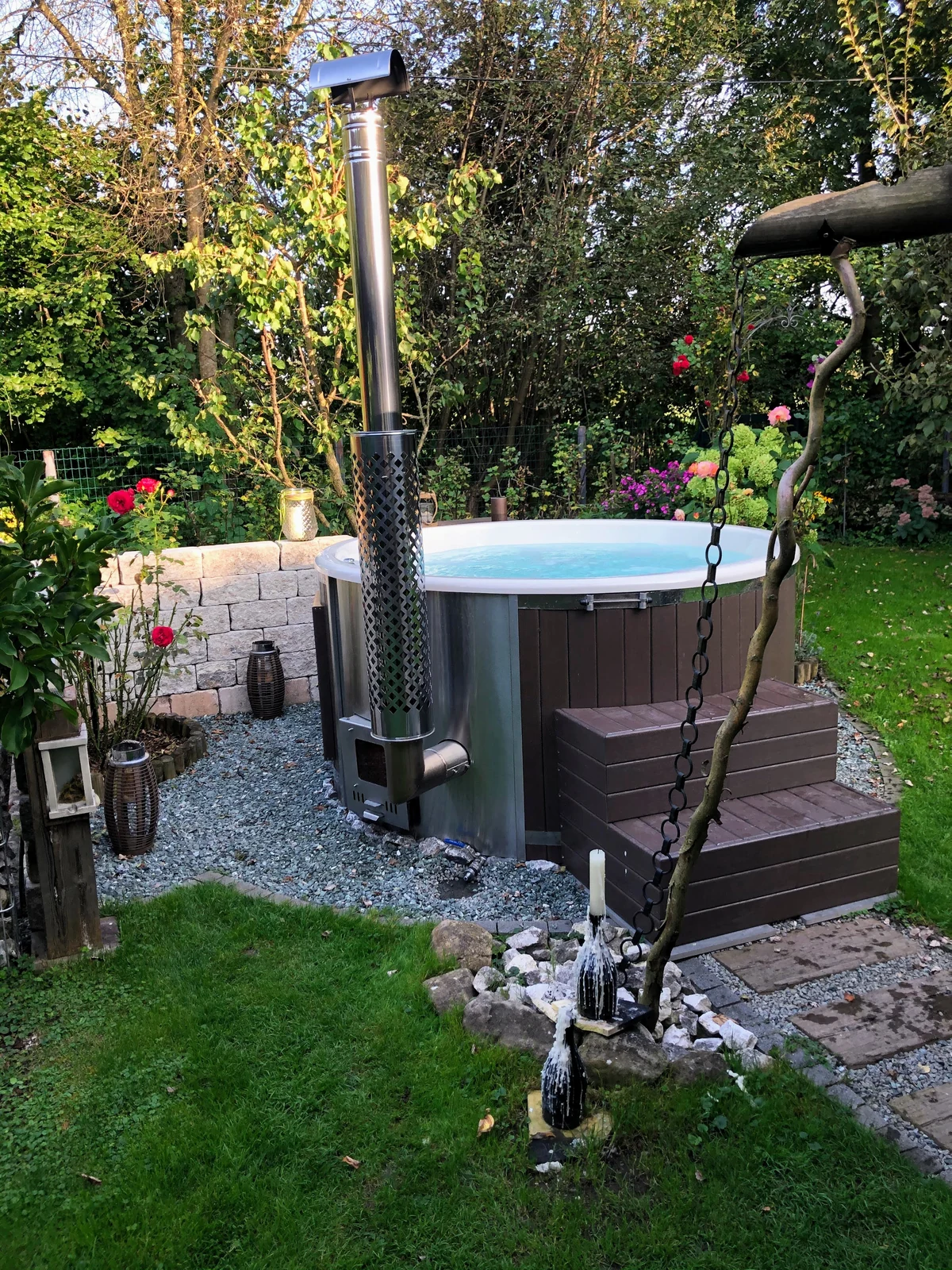 Hottub met trap en technische opstelling in een groene tuin