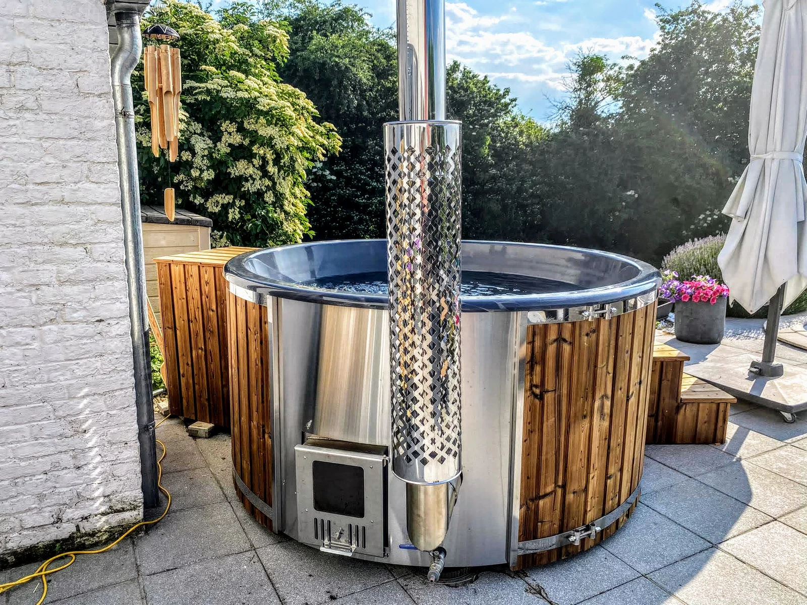 Hottub met externe kachel en schoorsteen op een terras