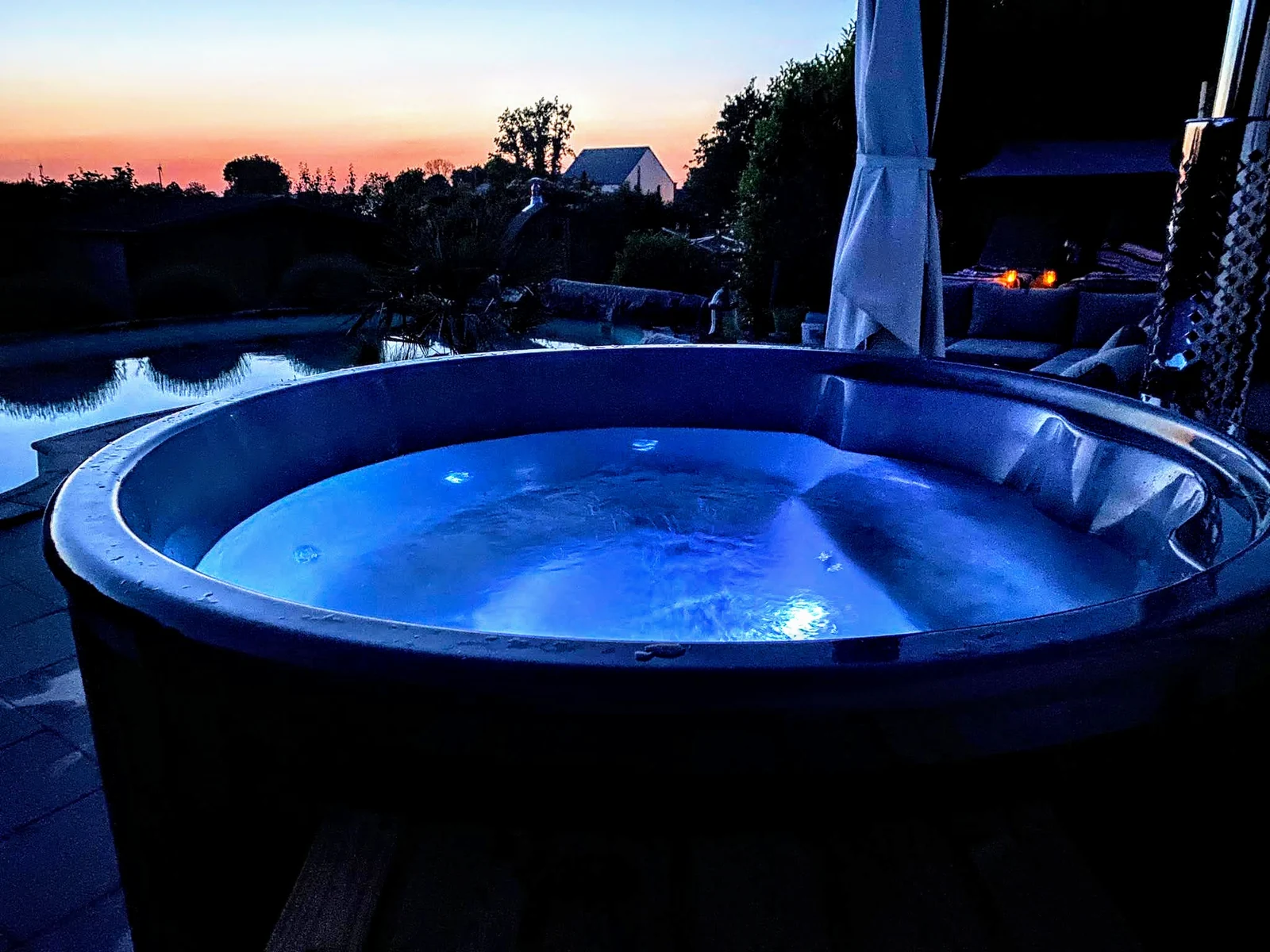 Hottub met verlicht water bij zonsondergang