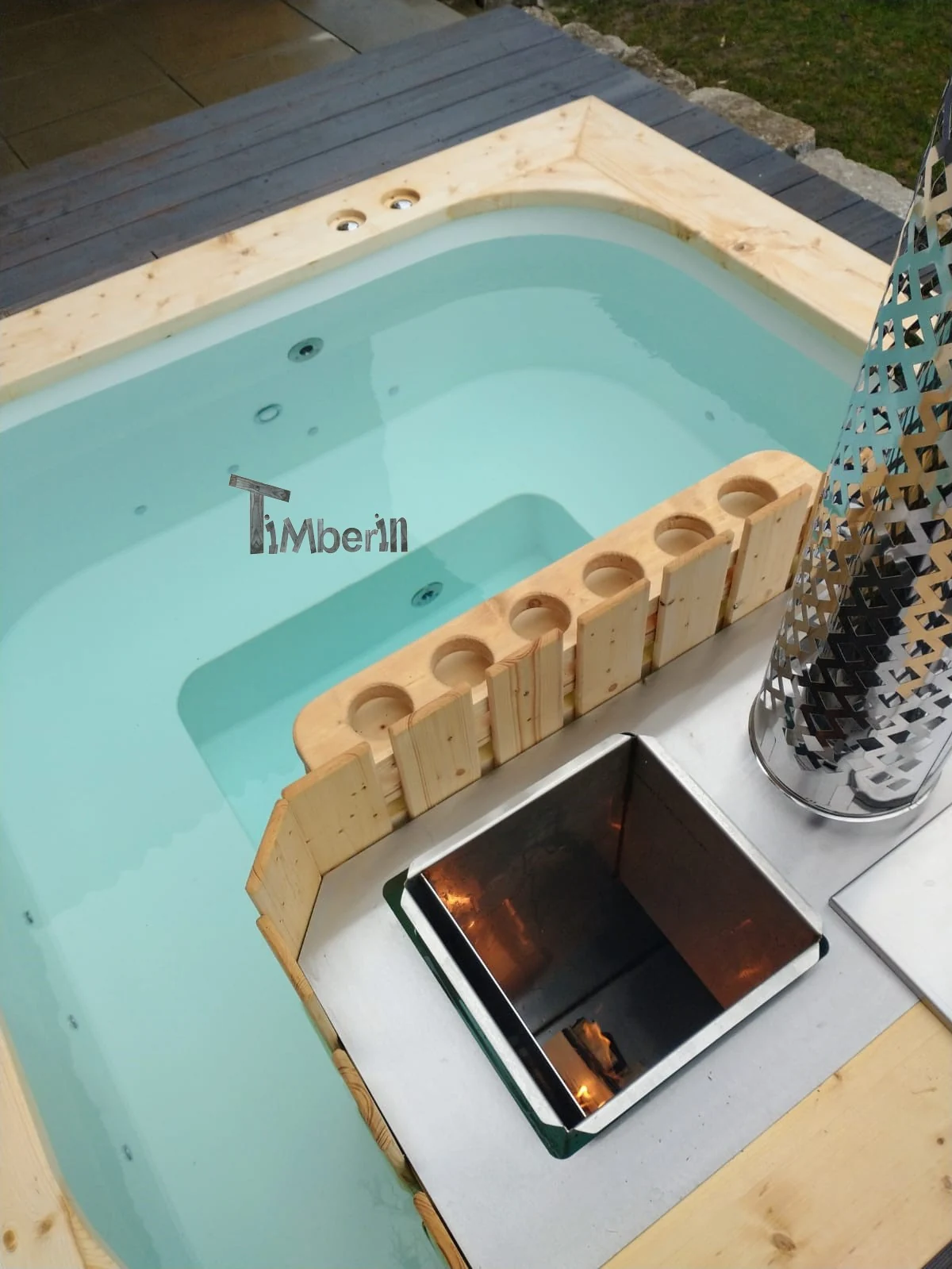 Detail van een hoekige hottub met houten rand en kachelzone