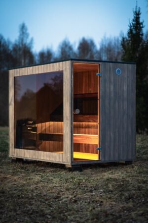 TimberIN Nordic Cube buitensauna met glazen front in de schemering