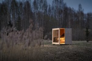 TimberIN Nordic Cube verlichte sauna in het avondbos